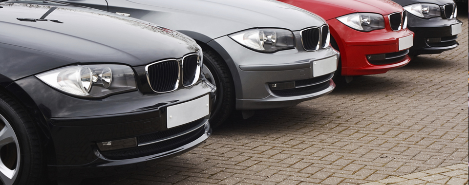 a black, silver and red car parked in a row